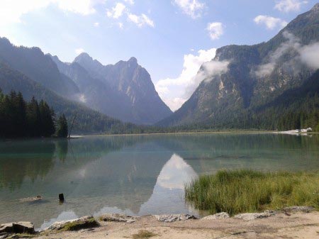 Lago di Dobbiaco Lago di Dobbiaco con montagne su sfondo e pezzo di costa
