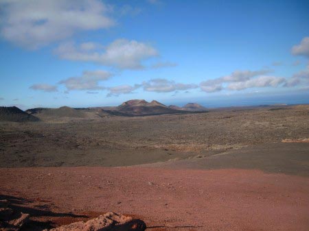 Terra rossa e marrone con vulcano in fondo