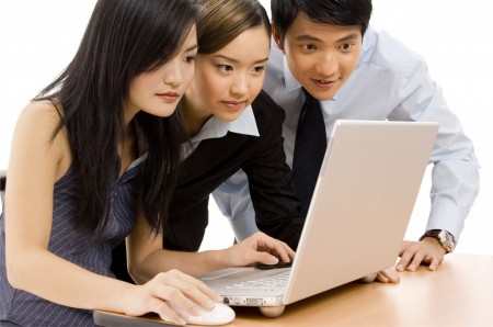 Due donne e un uomo orientali al laptop